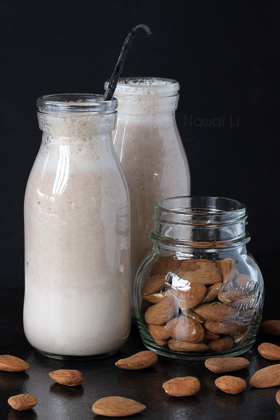 Fresh-made almond drink in two glasses with whole almonds in another glass beside them