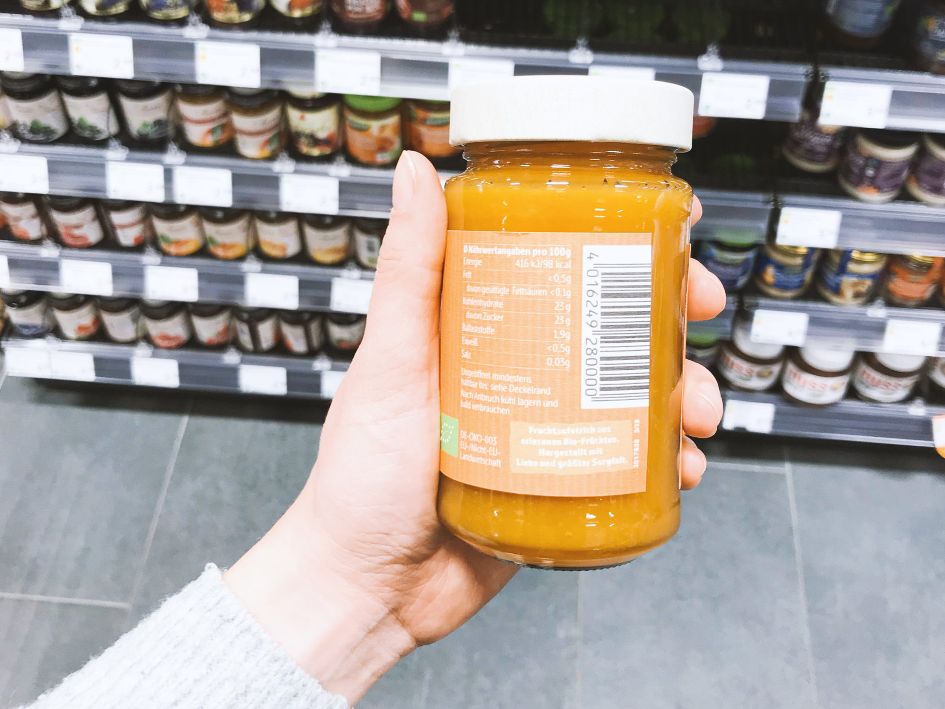 glass jar with nutrition label in one hand