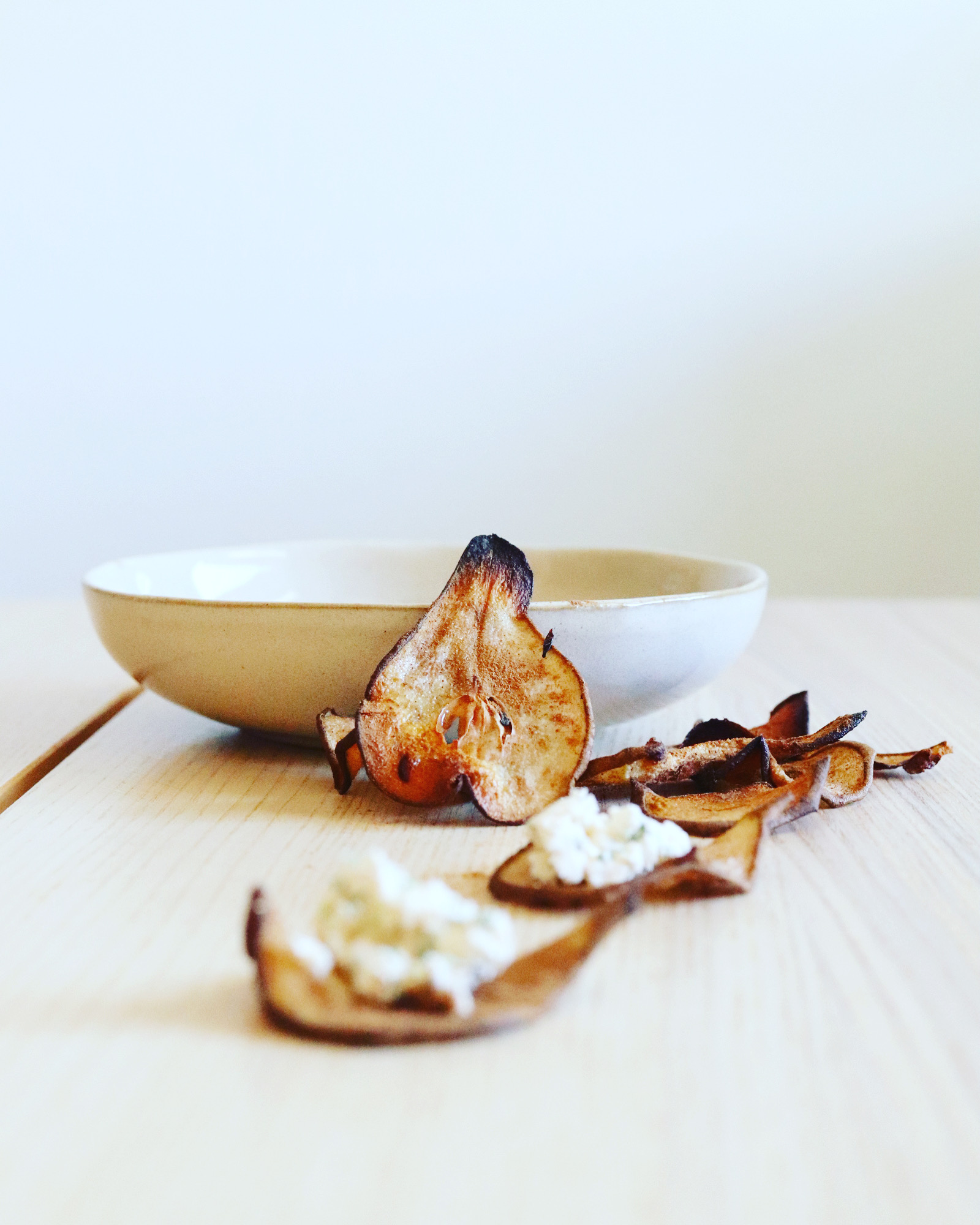 Pear crisps in front of a white bowl