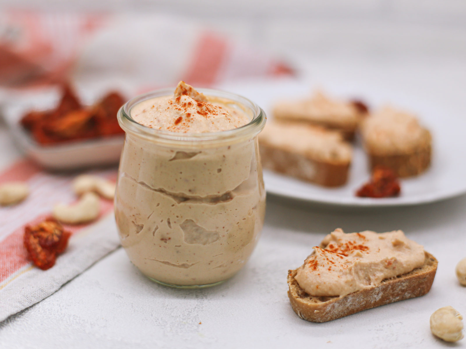 cashew tomato spread in a jar and on a piece of bread