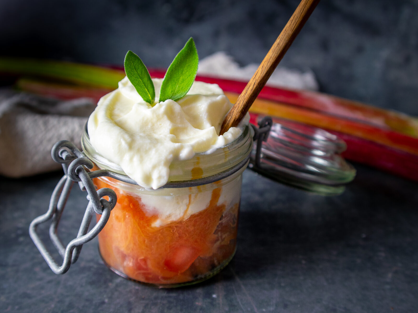 Rhubarb compote in a jar, topped with cream