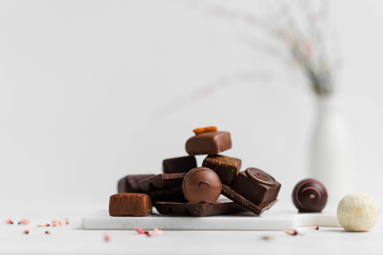 A mountain of pralines in front of a flower vase