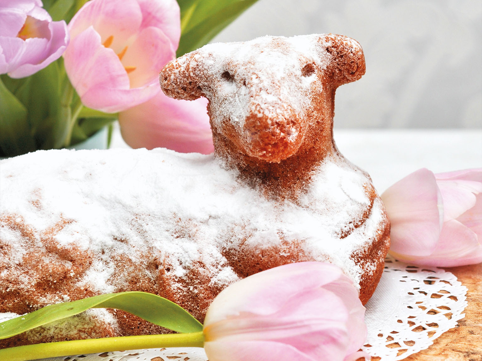 Easter lamb cake surrounded by pink tulips