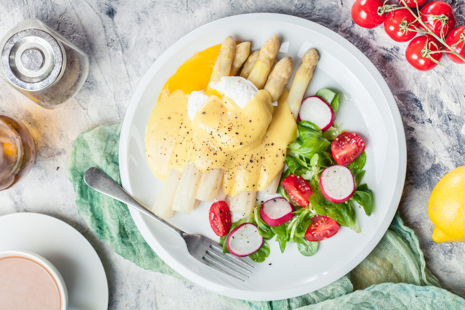 Weisse Spargeln mit Radiesli und Salat auf einem weissen Teller