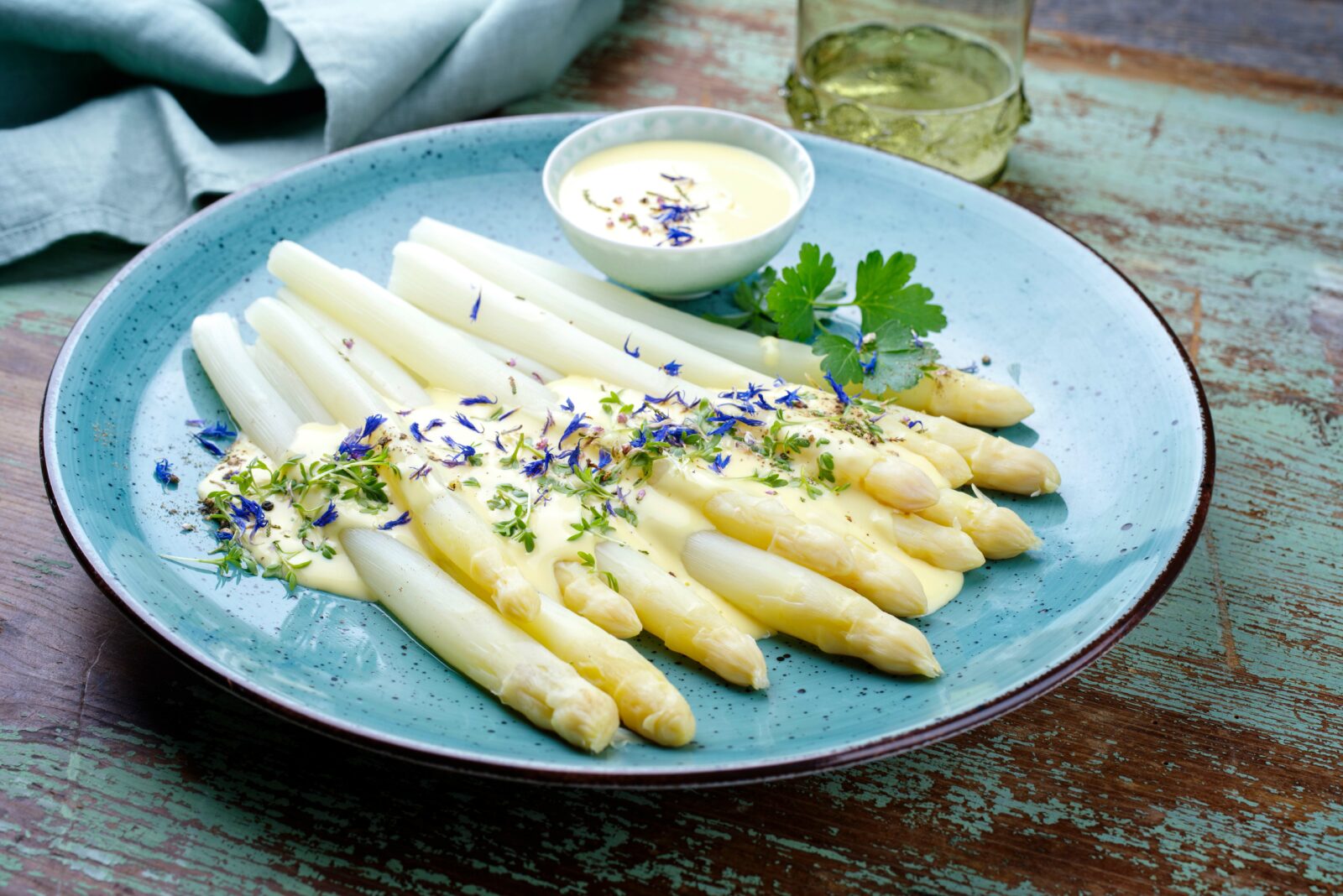 White asparagus with Sauce Hollandaise on a blue plate