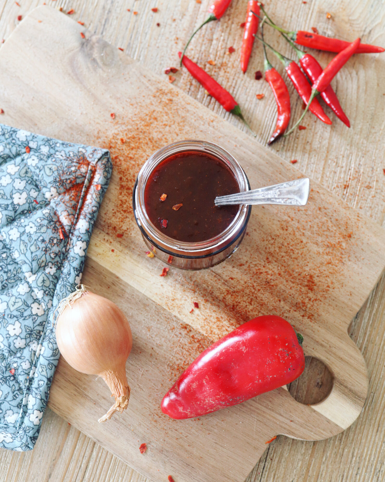 Barbecue sauce in a jar, onions and red peppers next to it