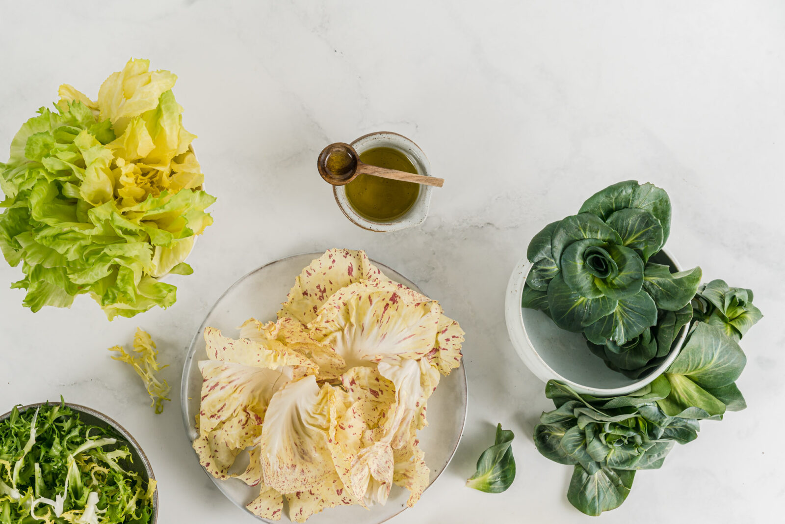 various kinds of salad on white marble background