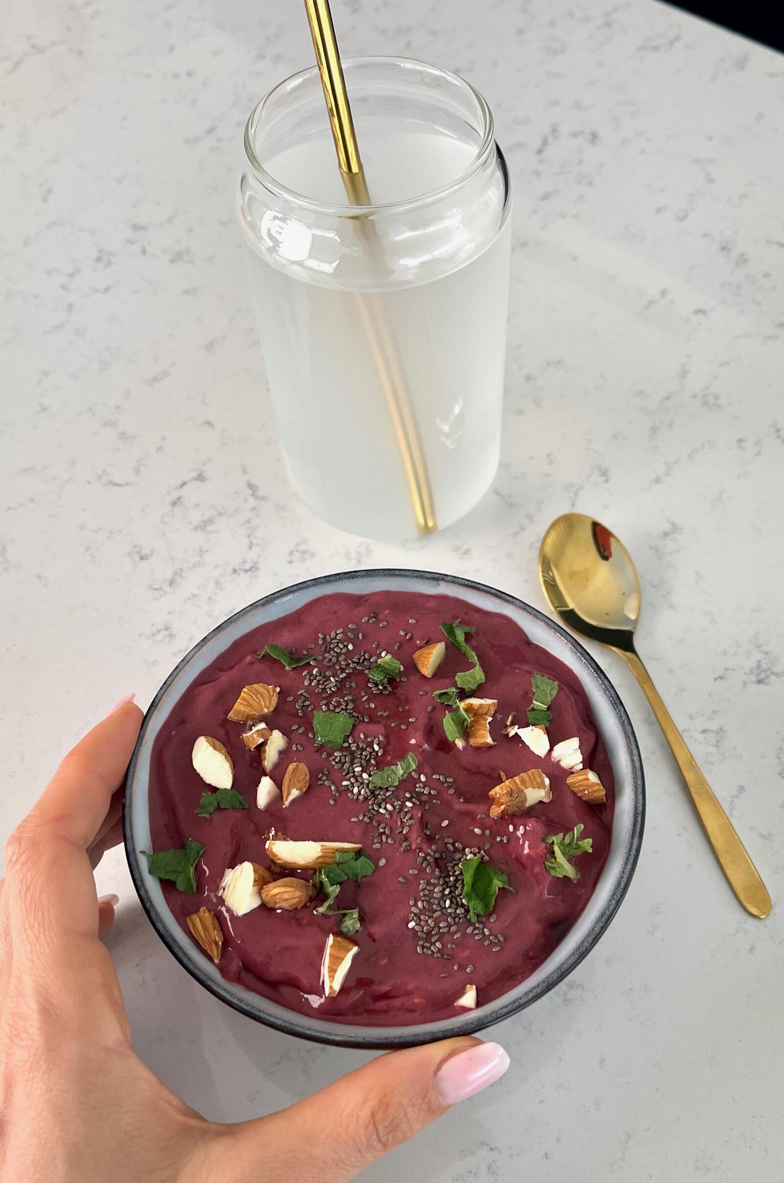 Bowl of acai topped with almonds and fresh mint