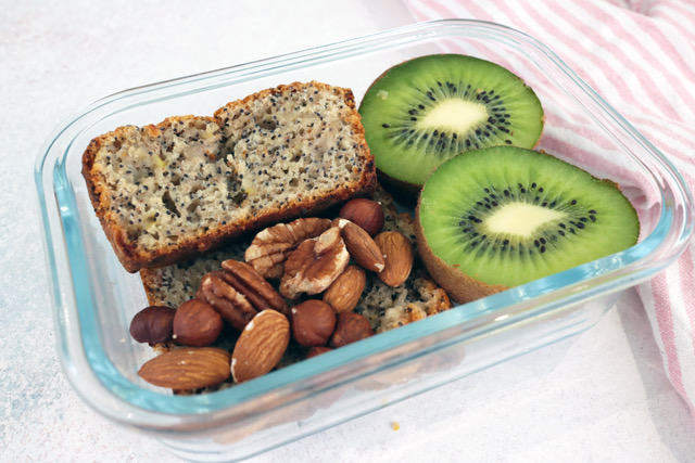 Lemon cake in a lunch box with cut-open kiwi and nuts