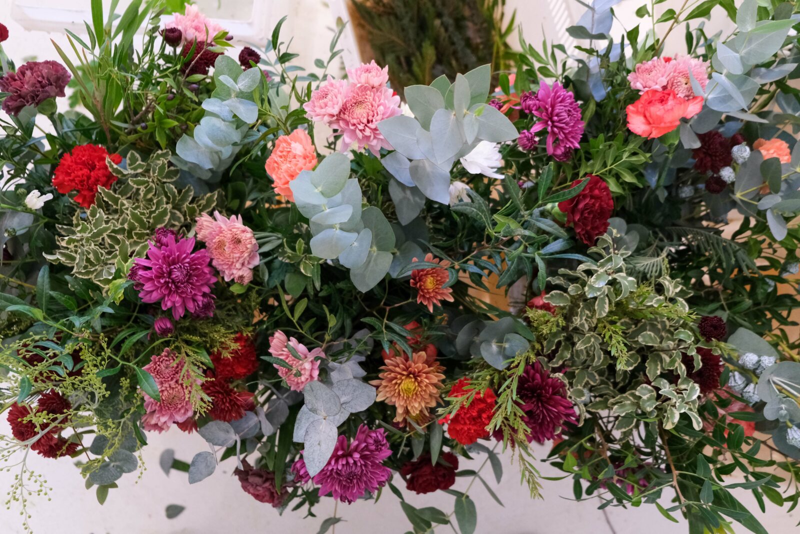 An arrange of flowers: chrysanthenum, eucalyptus, foliage