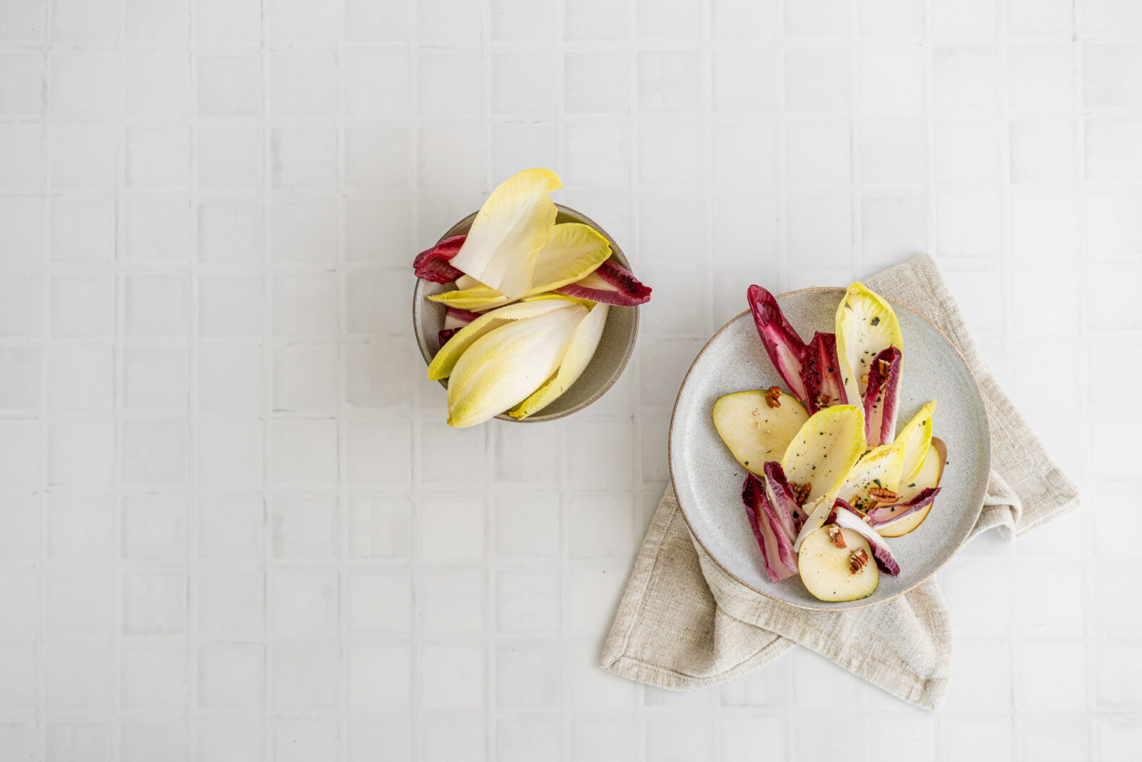 Red and white chicory in bowls, white background