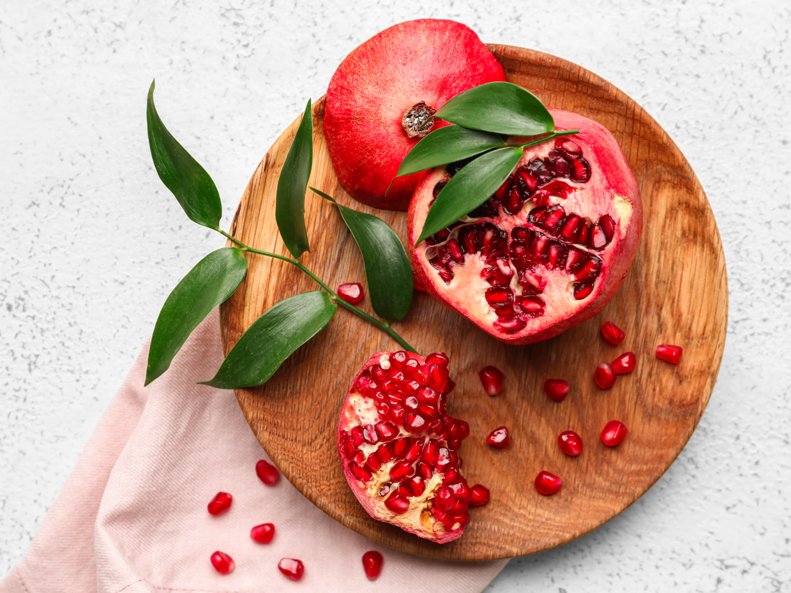 Pomegranade cut open on wooden board