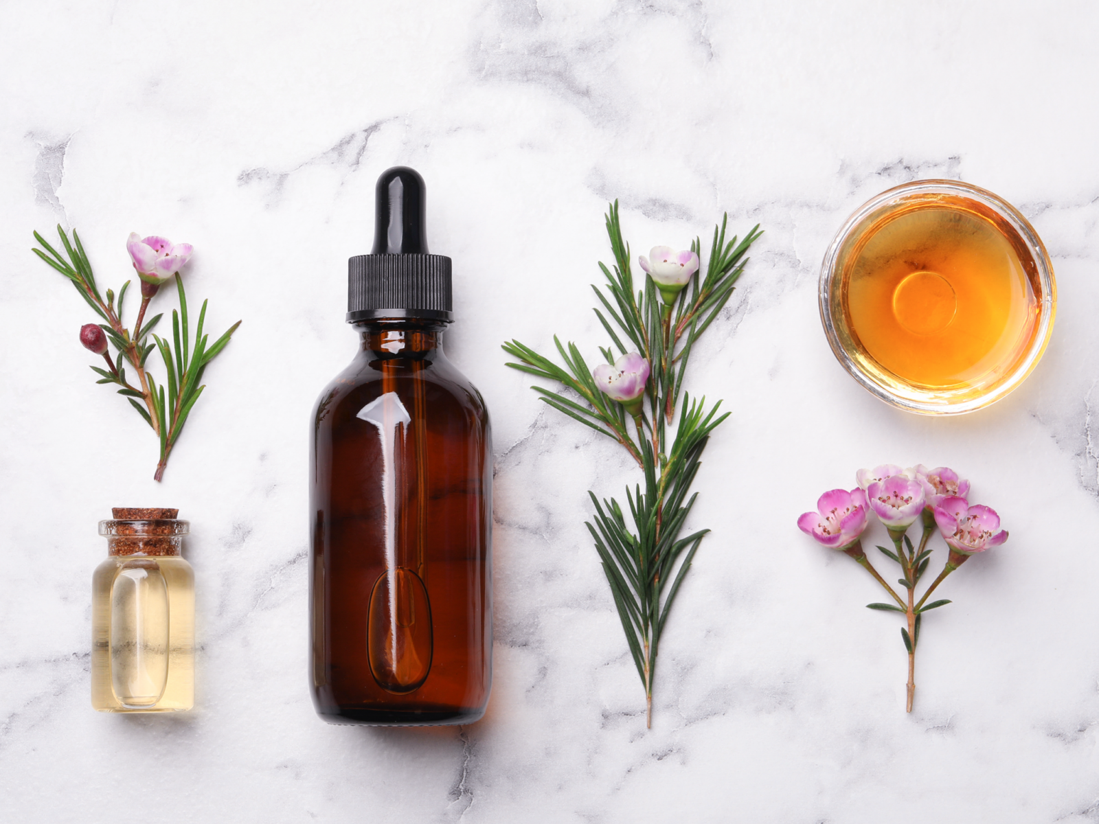 A vial of tea tree oil on white marble