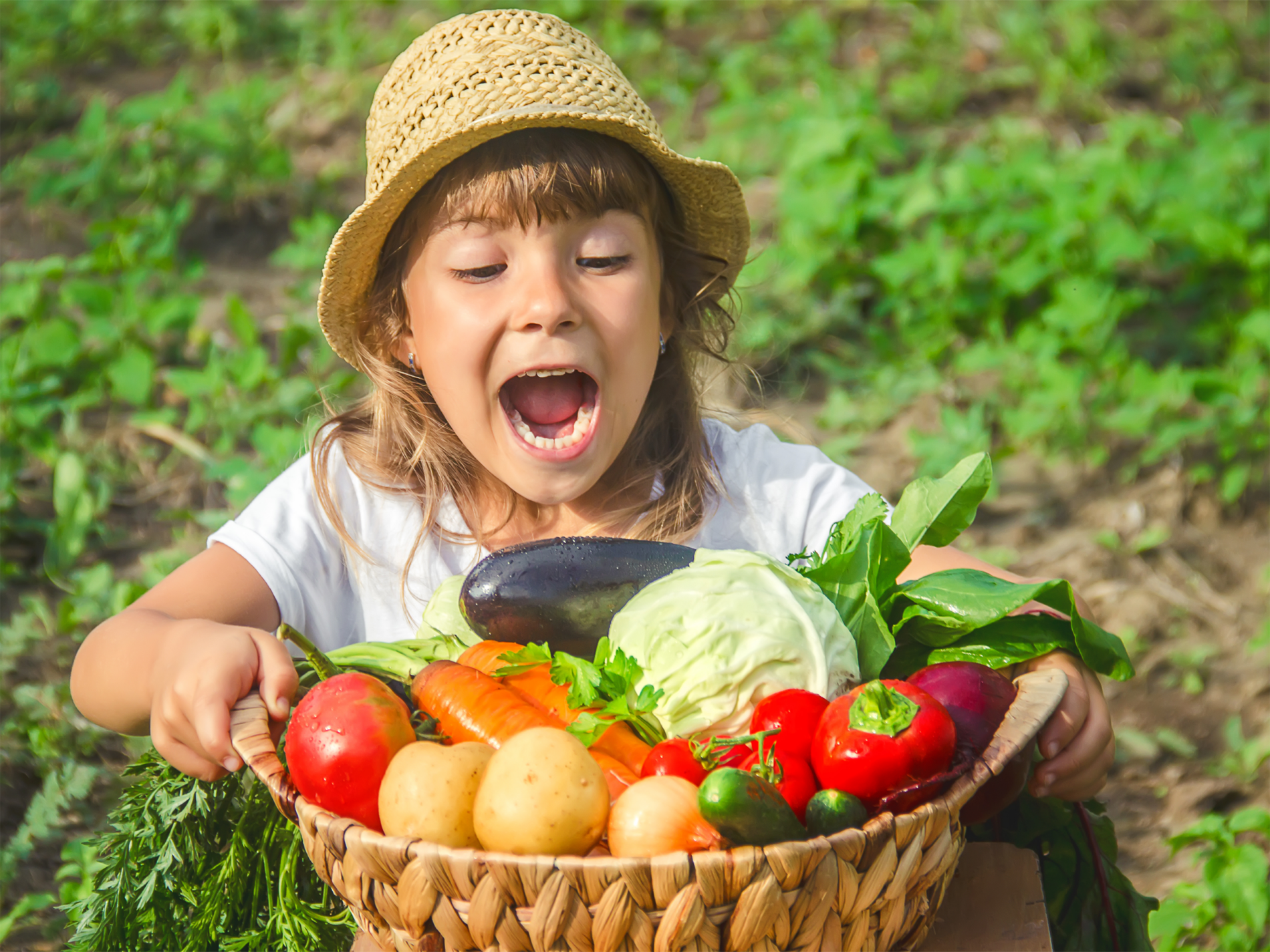 Child with a basket full of fresh veggies