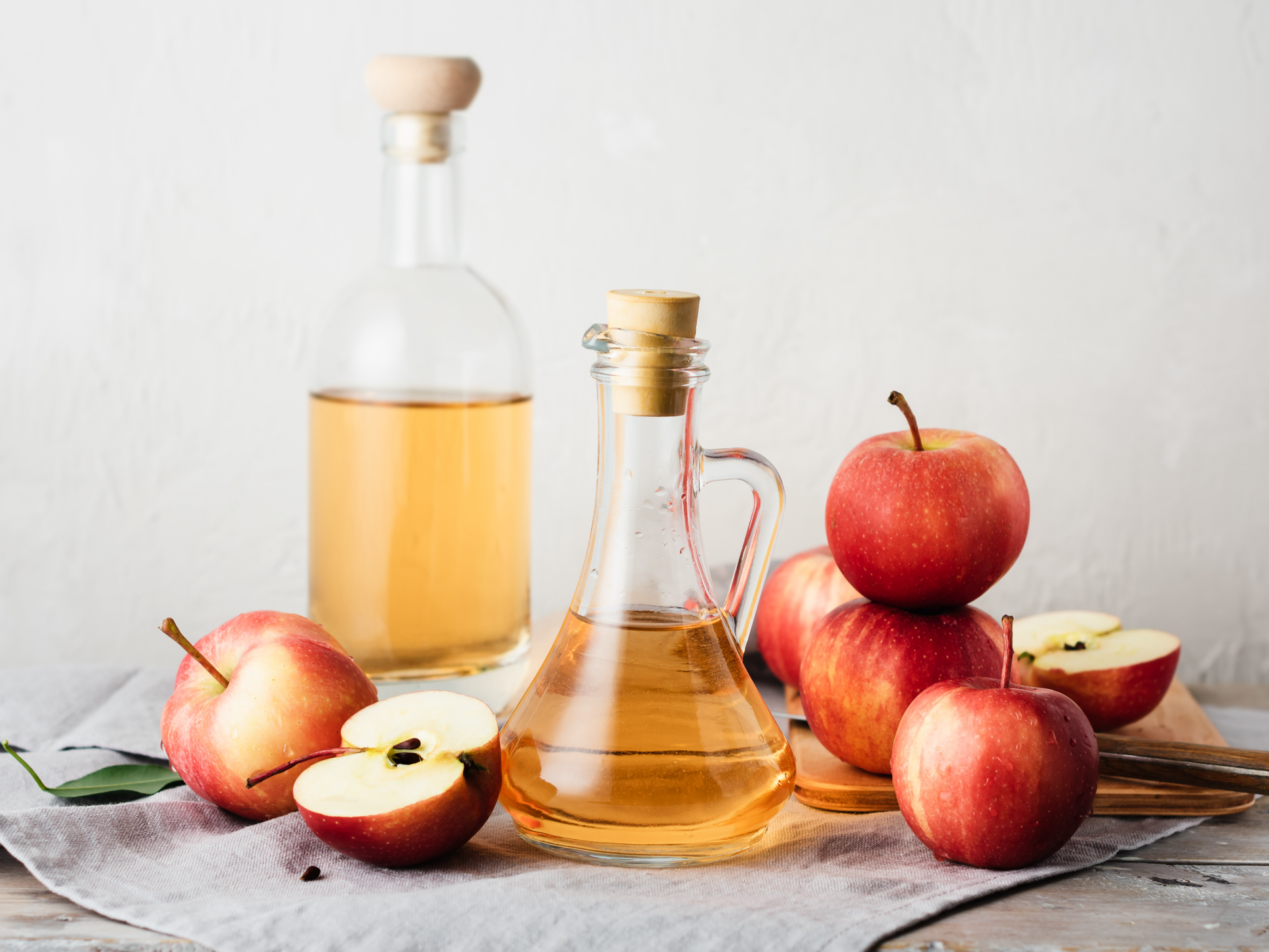 Apple cider vinegar next to fresh apples