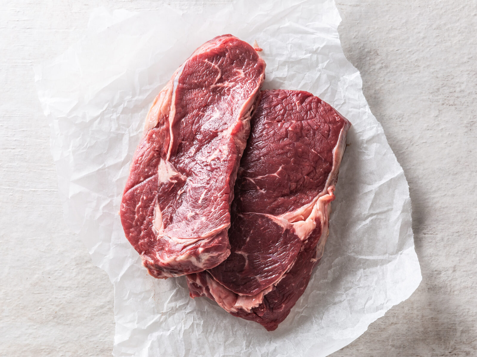 Two beef Rib eye steaks on white concrete table