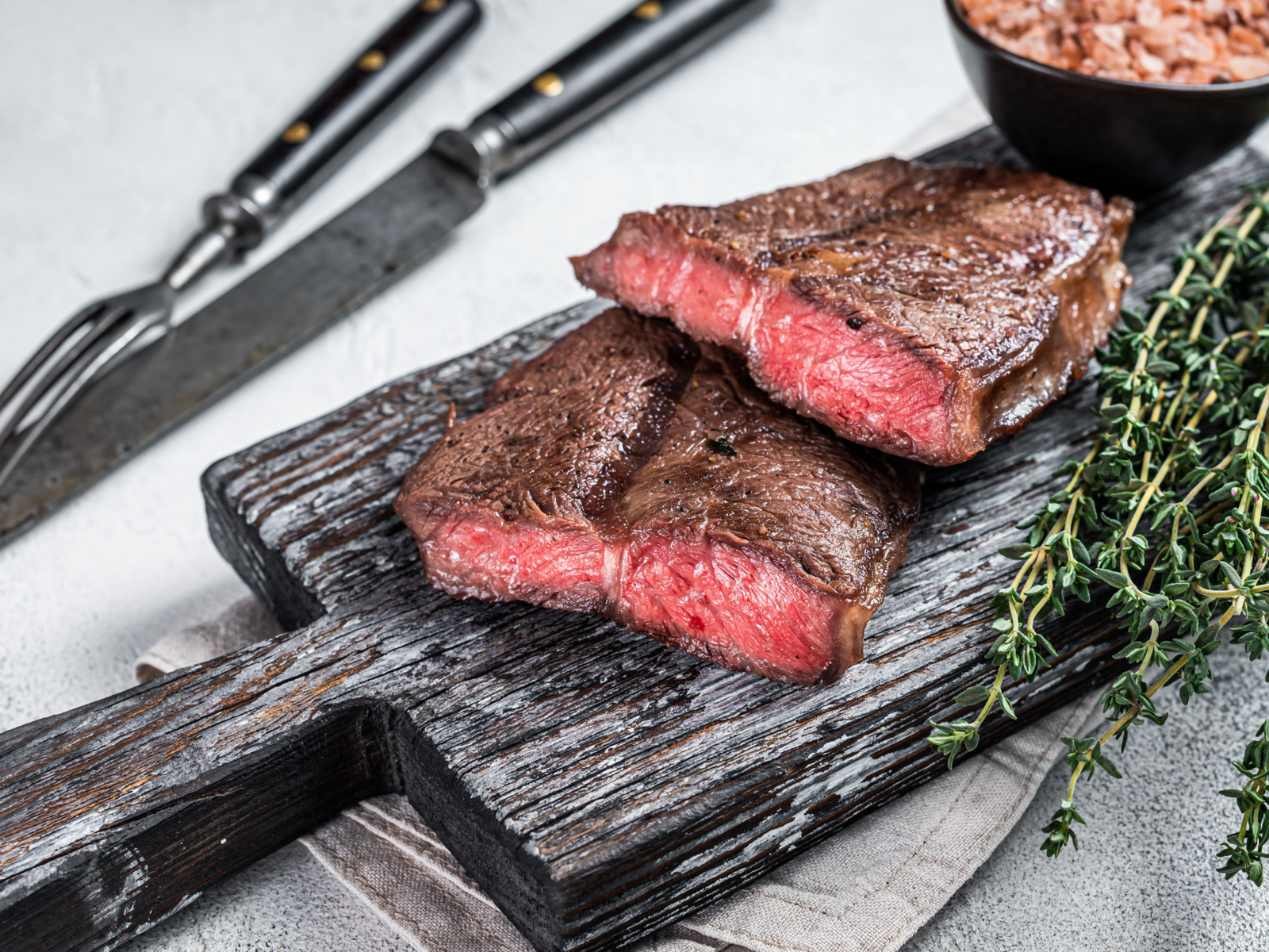 Two flat iron steaks on a wooden board