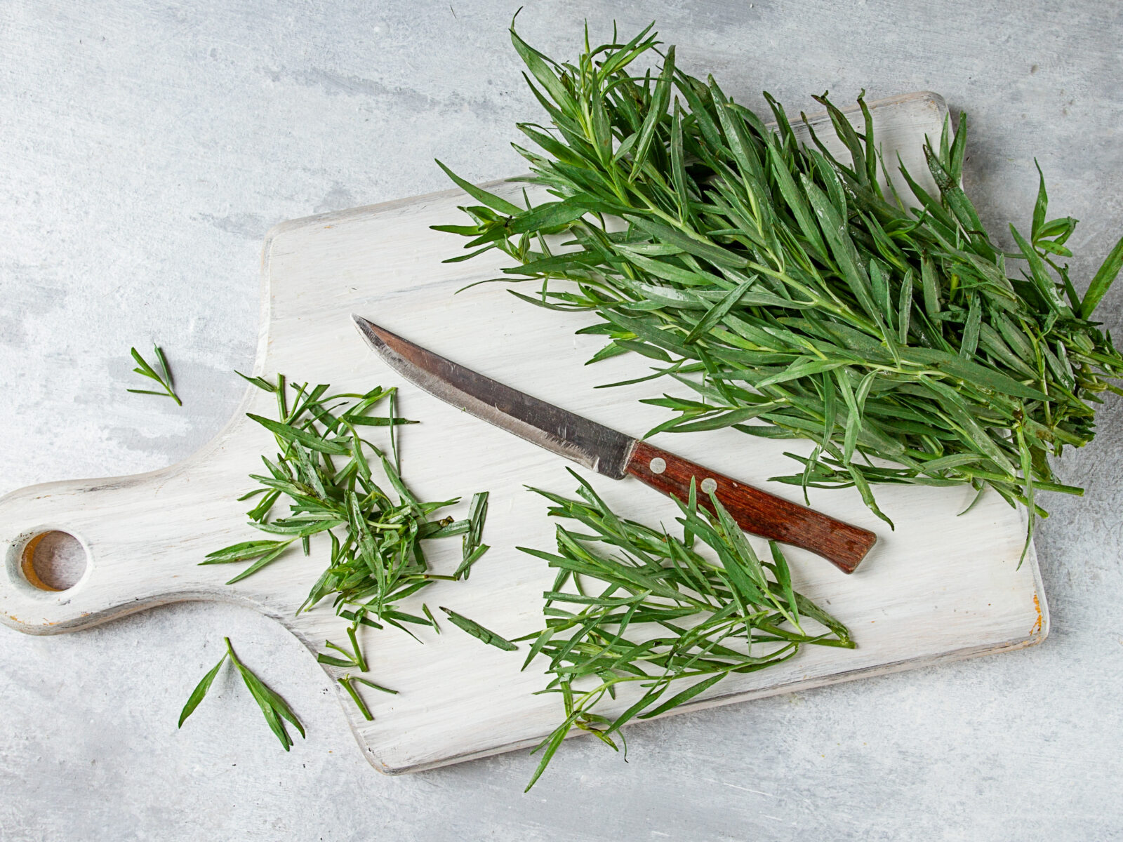 tarragon on a white cutting board