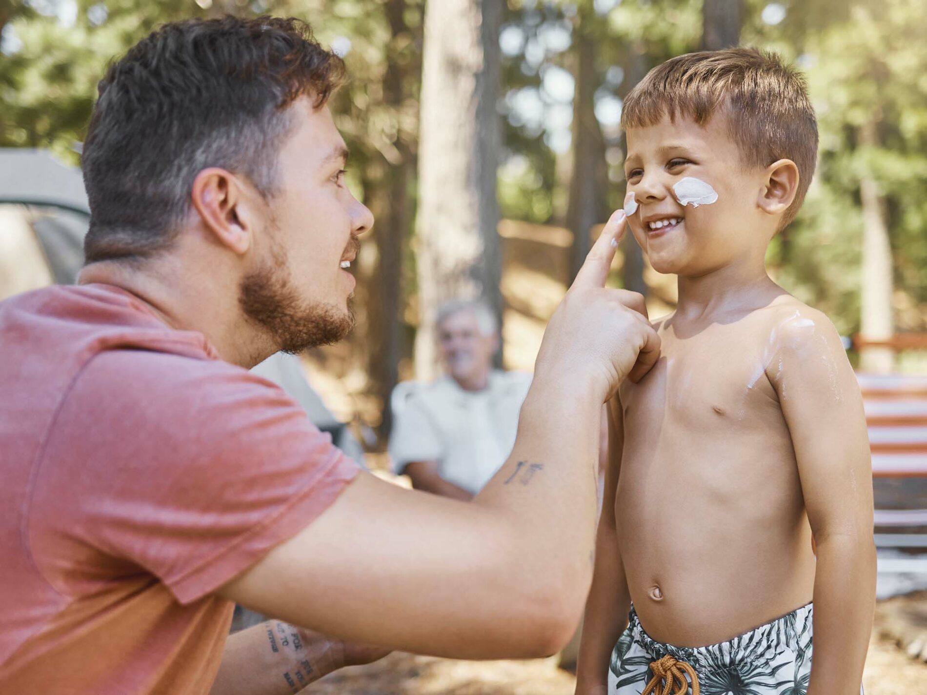 Father putting sun cream on a young boy's face