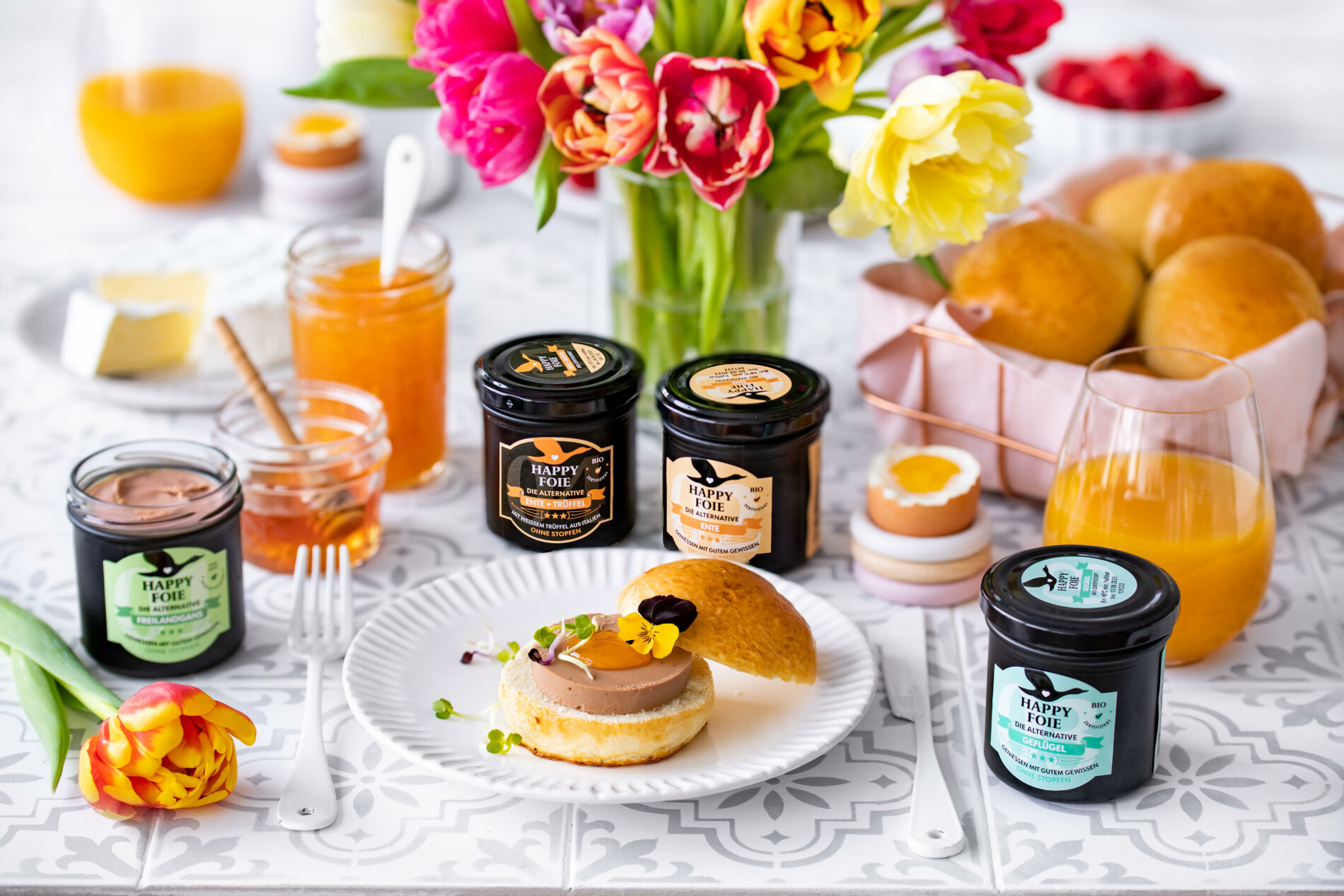 Foie gras products on a bright brunch table with flowers