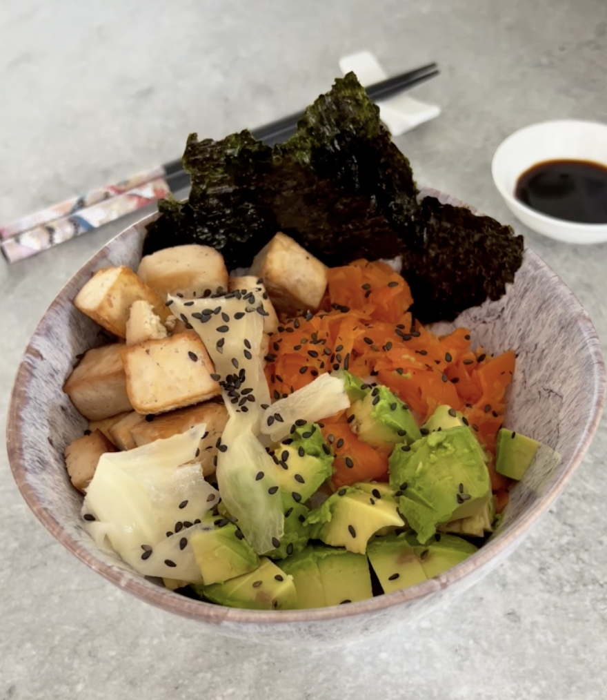 vegan sushi bowl with avocado, carrot salmon, pickled ginger, nori and fried tofu