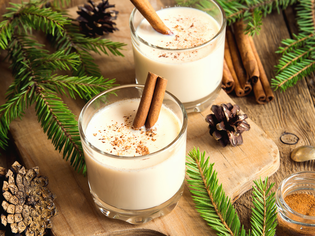Eggnog in two glasses with cinnamon sticks