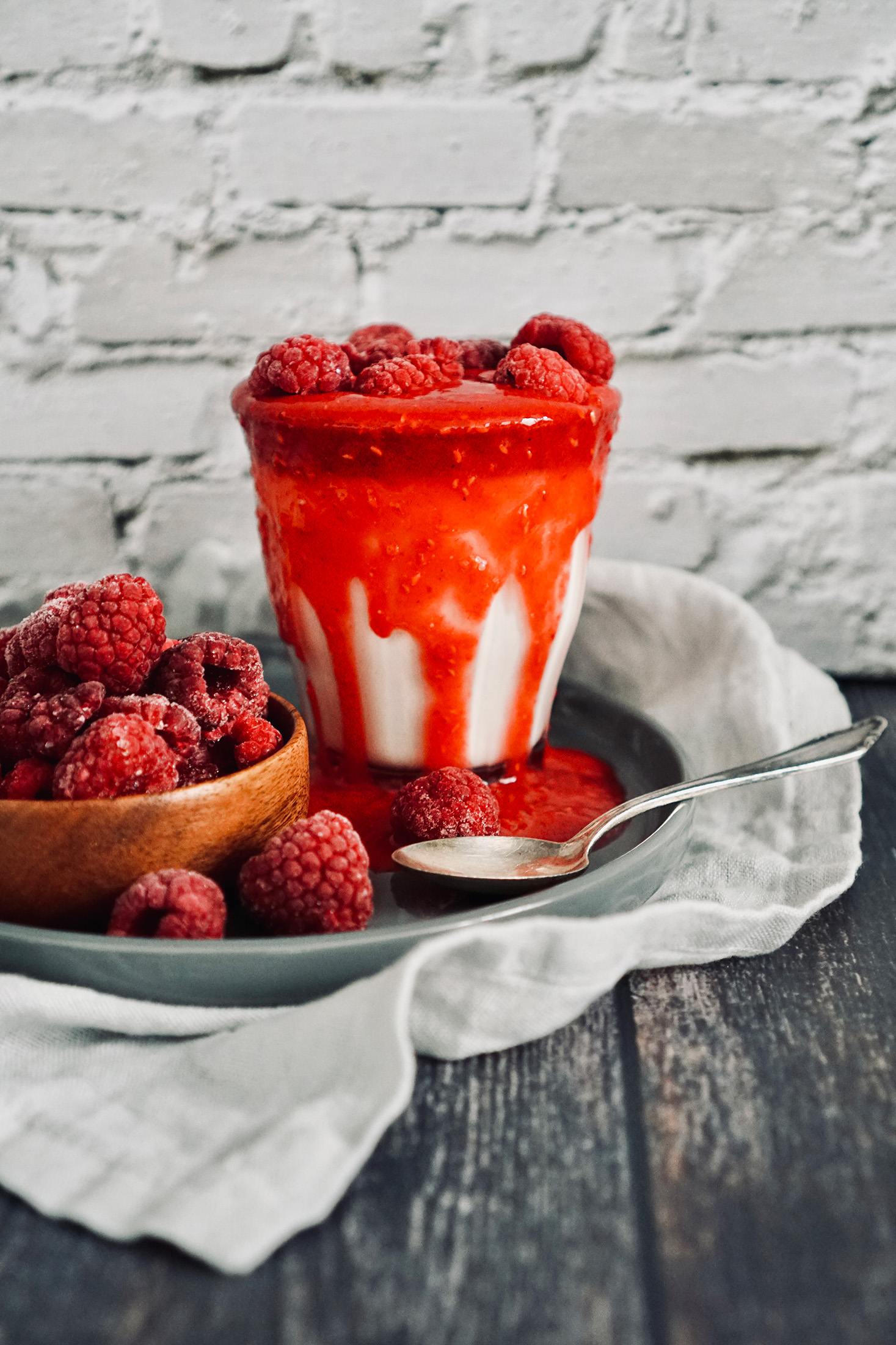 Vegan panna cotta in a glass with frozen raspberries