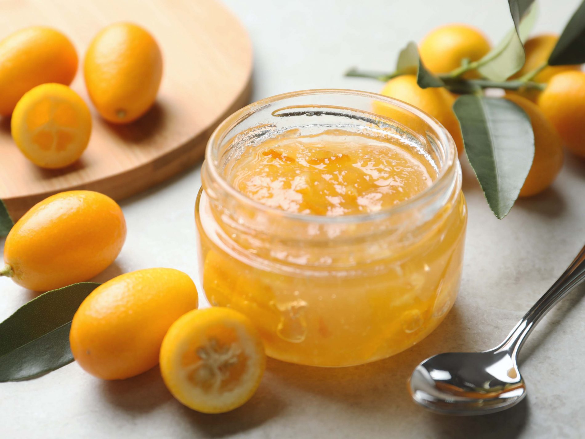 Whole Kumquat, with a jar of kumquat jam and a spoon