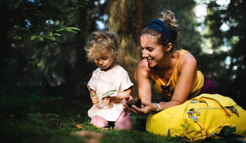 Portrait of happy mother with small daughter outdoors in summer